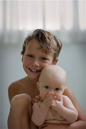Portrait of a young boy holding his baby brother. Stock Photo - Premium Royalty-Free, Code: 6128-08780387