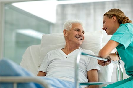 Portrait of a senior man in a hospital bed,  and a young female doctor. Stock Photo - Premium Royalty-Free, Code: 6128-08780741