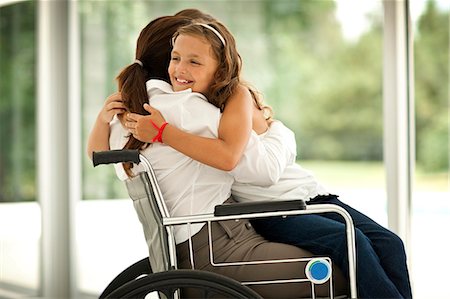 Senior woman in a wheelchair,  receiving a visit from her granddaughter. Stock Photo - Premium Royalty-Free, Code: 6128-08780723