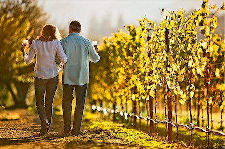 Mature couple enjoy romantic walk through vineyard while tasting wine. Stock Photo - Premium Royalty-Free, Code: 6128-08780943
