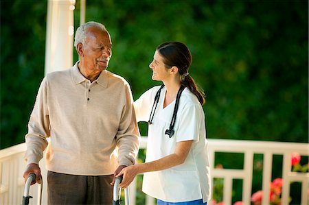 Young female nurse assisting an elderly patient with a walking frame on his verandah. Foto de stock - Sin royalties Premium, Código: 6128-08780954