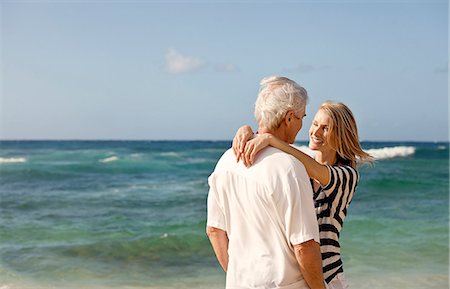 simsearch:6128-08738334,k - Mid adult woman hugging her husband on the beach. Stock Photo - Premium Royalty-Free, Code: 6128-08780933