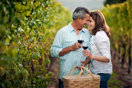 simsearch:6128-08738334,k - Mature couple sharing an intimate moment while drinking red wine in vineyard. Stock Photo - Premium Royalty-Free, Code: 6128-08780937