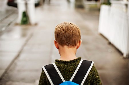 simsearch:695-03386286,k - Unhappy young boy walking with a school bag on his back. Stock Photo - Premium Royalty-Free, Code: 6128-08781061