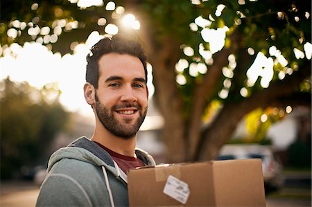 Portrait of smiling mid-adult man carrying moving box. Stock Photo - Premium Royalty-Free, Code: 6128-08781036