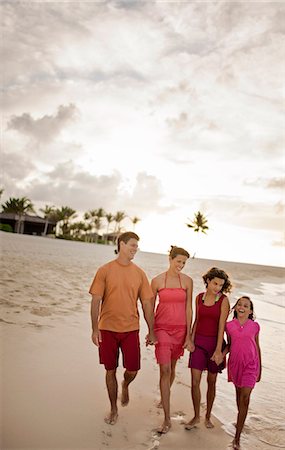 Mid-adult couple holding hands with their two teenage daughters as they walk together along a beach. Stock Photo - Premium Royalty-Free, Code: 6128-08798779