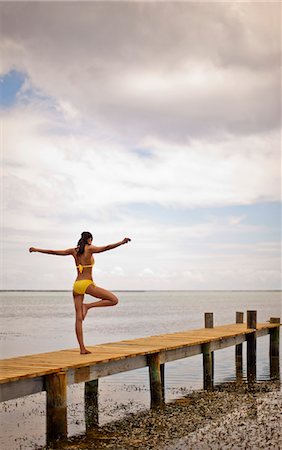 simsearch:633-01714467,k - Young woman doing yoga poses on the pier of a tropical island resort. Stock Photo - Premium Royalty-Free, Code: 6128-08798787