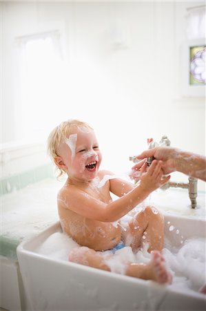 Laughing toddler having fun while taking a bubble bath. Stock Photo - Premium Royalty-Free, Code: 6128-08798737