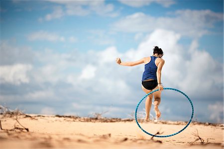 simsearch:633-01714467,k - Young woman using a hula hoop at the beach. Stock Photo - Premium Royalty-Free, Code: 6128-08798866