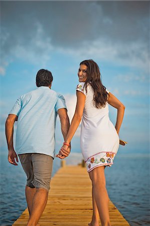 simsearch:6128-08738334,k - Happy mid adult couple walking hand in hand along a pier. Stock Photo - Premium Royalty-Free, Code: 6128-08798822