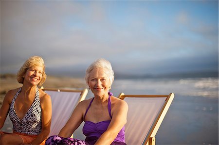 elderly ladies swimsuits - Two happy mature women relaxing in deck chairs on the beach. Stock Photo - Premium Royalty-Free, Code: 6128-08798938