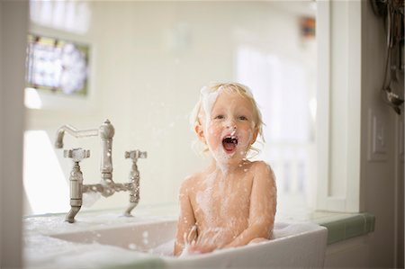 Portrait of a laughing toddler having fun while taking a bubble bath. Stock Photo - Premium Royalty-Free, Code: 6128-08727444