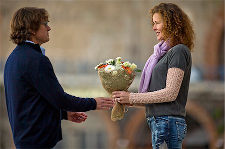 simsearch:6128-08738334,k - Middle aged man giving a beautiful bouquet of flowers to his date. Stock Photo - Premium Royalty-Free, Code: 6128-08727648
