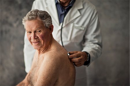 Mature doctor listening to an elderly patient's heartbeat with a stethoscope. Stock Photo - Premium Royalty-Free, Code: 6128-08727791