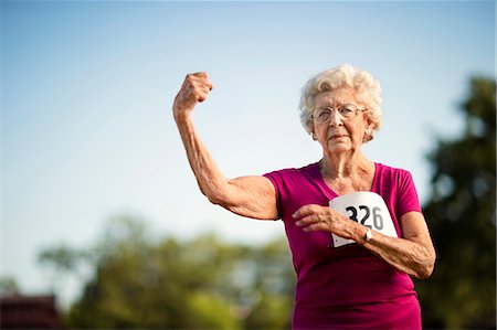 serious older woman looking at camera - Portrait of a strong senior woman flexing her arm muscle. Stock Photo - Premium Royalty-Free, Code: 6128-08727850