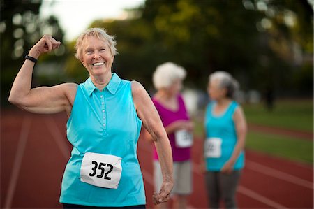 elderly excercising - Portrait of a smiling senior woman flexing her arm muscles. Stock Photo - Premium Royalty-Free, Code: 6128-08727863