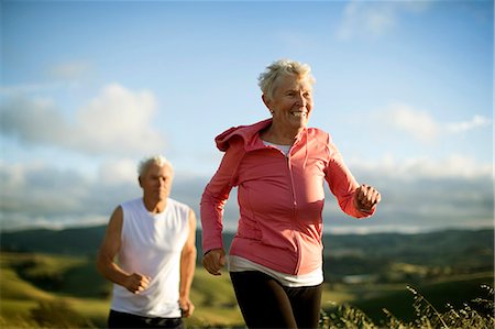 retired happy active - Senior couple jogging together in a rural landscape. Stock Photo - Premium Royalty-Free, Code: 6128-08727809