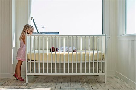 stand infant - Young girl peeking into her baby sister's crib. Photographie de stock - Premium Libres de Droits, Code: 6128-08728092