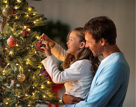 Happy father and daughter decorating a Christmas tree together. Stock Photo - Premium Royalty-Free, Code: 6128-08728285