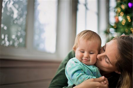 Mother kissing her baby daughter on the cheek. Stock Photo - Premium Royalty-Free, Code: 6128-08728302