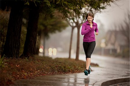 residential - Young woman jogging on a residential street. Stock Photo - Premium Royalty-Free, Code: 6128-08737592