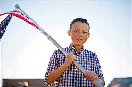 Portrait of a young boy holding an American flag. Stock Photo - Premium Royalty-Free, Code: 6128-08737861