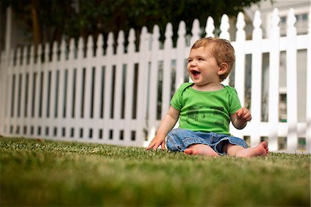 photo picket garden - Happy young boy sitting on the grass in the backyard. Stock Photo - Premium Royalty-Free, Code: 6128-08737823