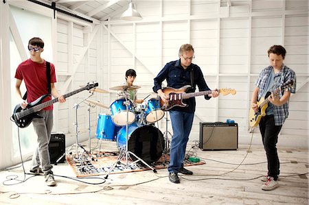 simsearch:649-07063808,k - Three teenage boys and a man have a jam session on electric guitars and drums. Stock Photo - Premium Royalty-Free, Code: 6128-08737936