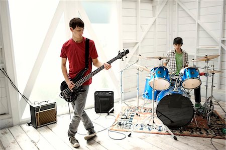 Two teenage males having a jam session on an electric guitar and drums. Stock Photo - Premium Royalty-Free, Code: 6128-08737939