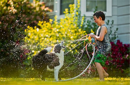 sleeveless top - Happy young boy and dog playing with a sprinkler. Stock Photo - Premium Royalty-Free, Code: 6128-08738382