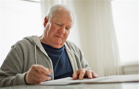 document - Senior man looking over important documents. Stock Photo - Premium Royalty-Free, Code: 6128-08738329