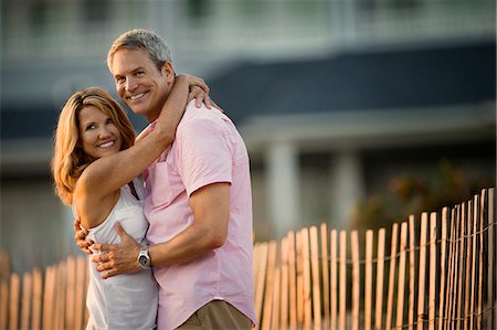simsearch:6128-08738334,k - Mature couple smiling and embracing on the beach at sunset. Stock Photo - Premium Royalty-Free, Code: 6128-08738483