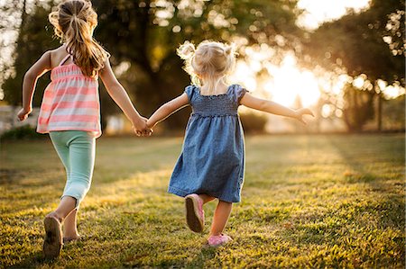 running casual - Siblings running hand in hand through a park. Photographie de stock - Premium Libres de Droits, Code: 6128-08738542