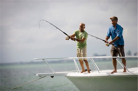 simsearch:673-02140194,k - Two smiling mature men fishing off the edge of a boat together in the ocean. Stock Photo - Premium Royalty-Free, Code: 6128-08840922