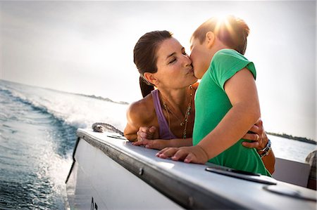 simsearch:632-05816381,k - Happy mother kissing her son on the deck of a boat. Stock Photo - Premium Royalty-Free, Code: 6128-08841052