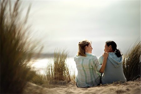 friend console - Two friends having a heart-to-heart talk while sitting on the beach. Stock Photo - Premium Royalty-Free, Code: 6128-08841005