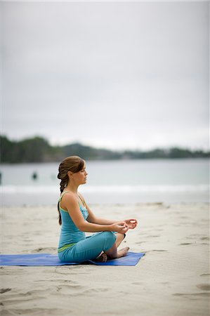 simsearch:700-08743683,k - Young adult girl meditating while sitting doing yoga with her mid-adult mother and mature grandmother on a beach. Stock Photo - Premium Royalty-Free, Code: 6128-08825393