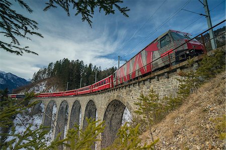 Filisur, Switzerland. The red train running away on the viaduct. Stock Photo - Premium Royalty-Free, Code: 6129-09044135