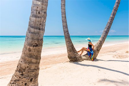 sarong - Juanillo Beach (playa Juanillo), Punta Cana, Dominican Republic. Woman under high palm trees on the beach (MR) Stock Photo - Premium Royalty-Free, Code: 6129-09044547