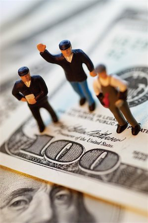 simsearch:625-00801281,k - Three toy men standing on top of United States one hundred dollar bills, close-up Stock Photo - Premium Royalty-Free, Code: 625-00801256