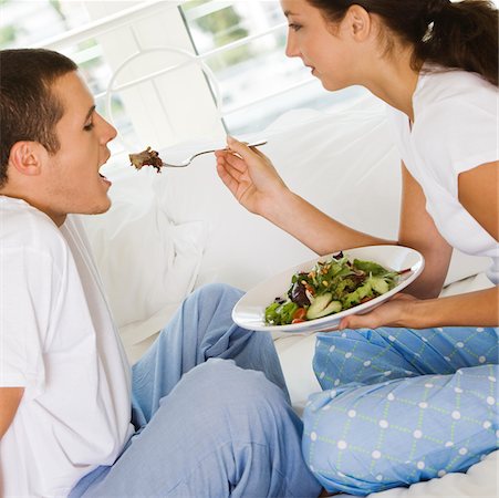 simsearch:625-00839074,k - Side profile of a young woman feeding a young man salad Stock Photo - Premium Royalty-Free, Code: 625-00837627