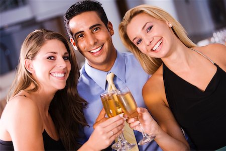 simsearch:625-00902698,k - Two young women and a young man toasting with champagne flutes Foto de stock - Sin royalties Premium, Código: 625-00838314
