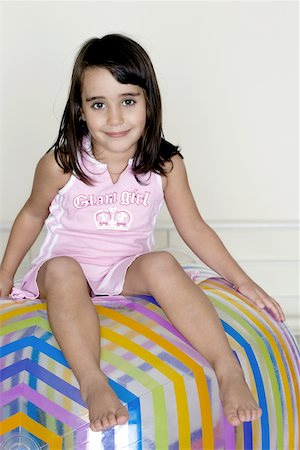 Portrait of a girl sitting on a large inflatable ball Stock Photo - Premium Royalty-Free, Code: 625-00838609