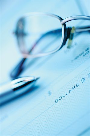 simsearch:625-00840035,k - Close-up of a pen and a pair of eyeglasses on a check Stock Photo - Premium Royalty-Free, Code: 625-00839975