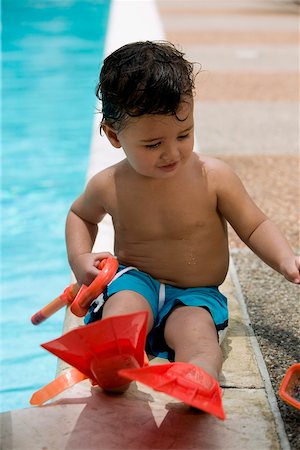 simsearch:625-01748893,k - Close-up of a boy holding snorkel sitting by the pool Stock Photo - Premium Royalty-Free, Code: 625-00849003
