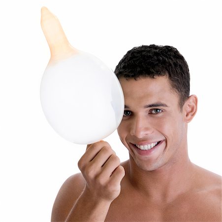 Portrait of a young man holding a blown condom Stock Photo - Premium Royalty-Free, Code: 625-00841286