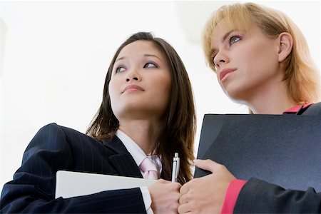 simsearch:625-01097830,k - Low angle view of two businesswomen holding a laptop and a file Stock Photo - Premium Royalty-Free, Code: 625-00850558