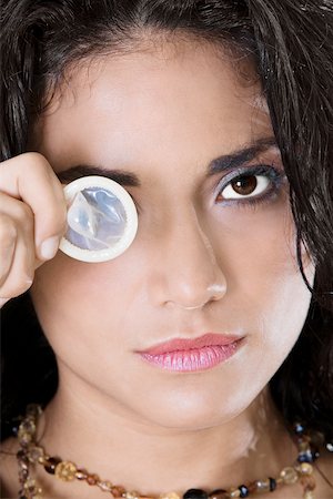 Portrait of a young woman holding a condom Stock Photo - Premium Royalty-Free, Code: 625-00850675