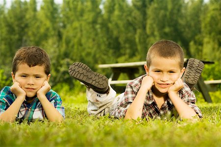 Portrait de deux garçons couchés sur la pelouse Photographie de stock - Premium Libres de Droits, Code: 625-00899681