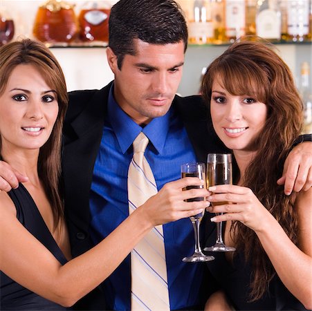 simsearch:625-00902698,k - Close-up of a mid adult man with his arms over two young women Foto de stock - Sin royalties Premium, Código: 625-00900216